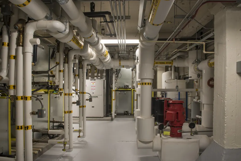 Insulated pipe runs and elbows in a basement mechanical room in Grand Junction, Colorado